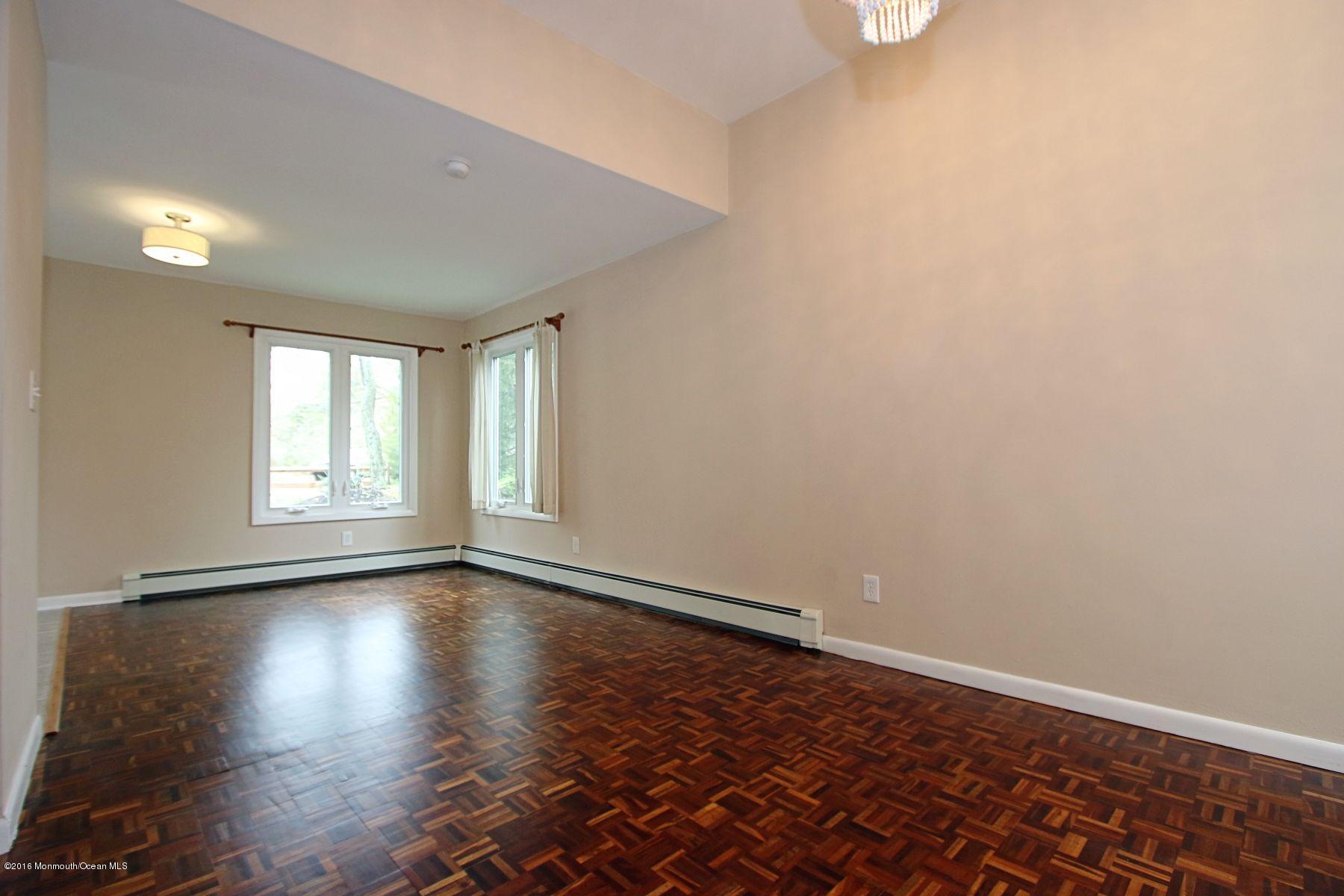 186 Pinebrook Road Tinton Falls, NJ 07724 - Photo 21 of 41 wooden floor in an empty room with a window