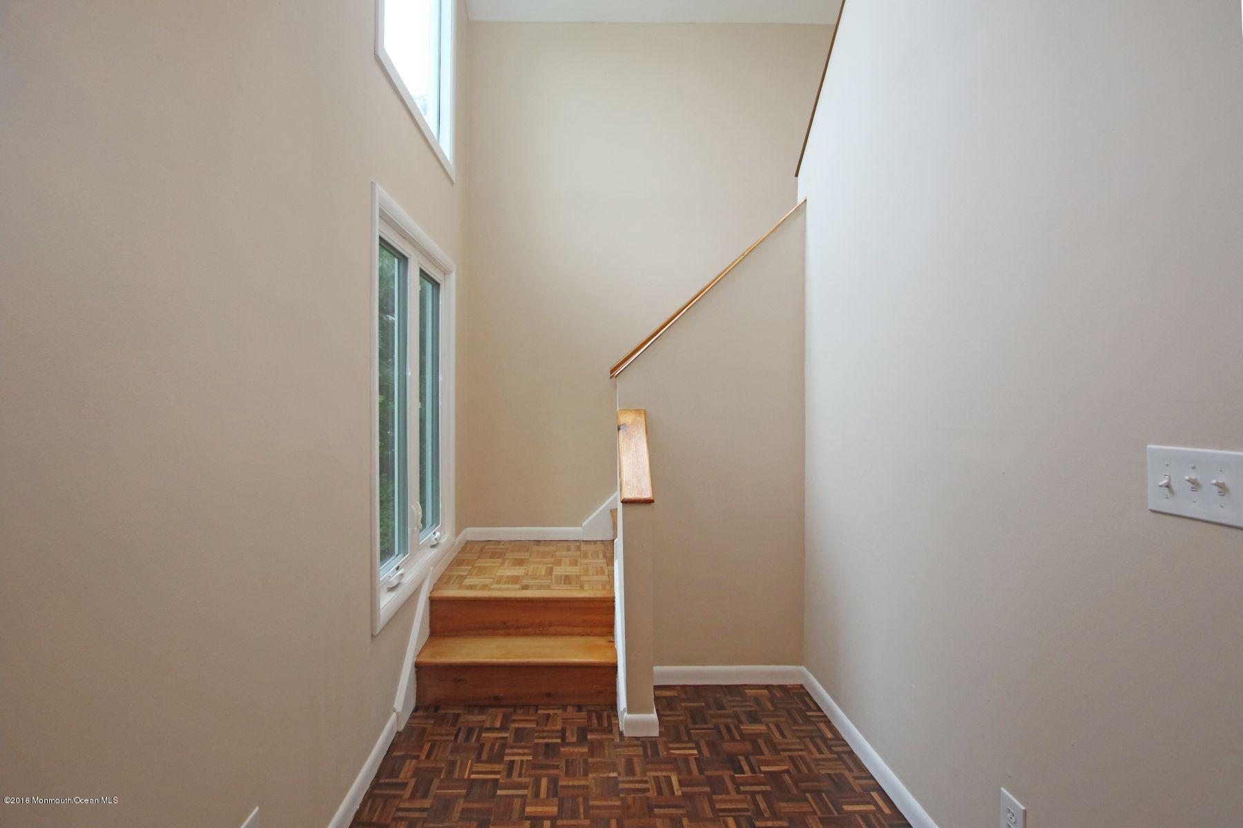 186 Pinebrook Road Tinton Falls, NJ 07724 - Photo 28 of 41 a view of a hallway with wooden floor and staircase