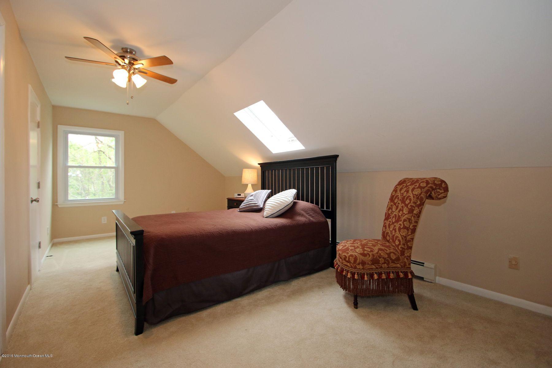 186 Pinebrook Road Tinton Falls, NJ 07724 - Photo 30 of 41 a bedroom with a bed and a chandelier