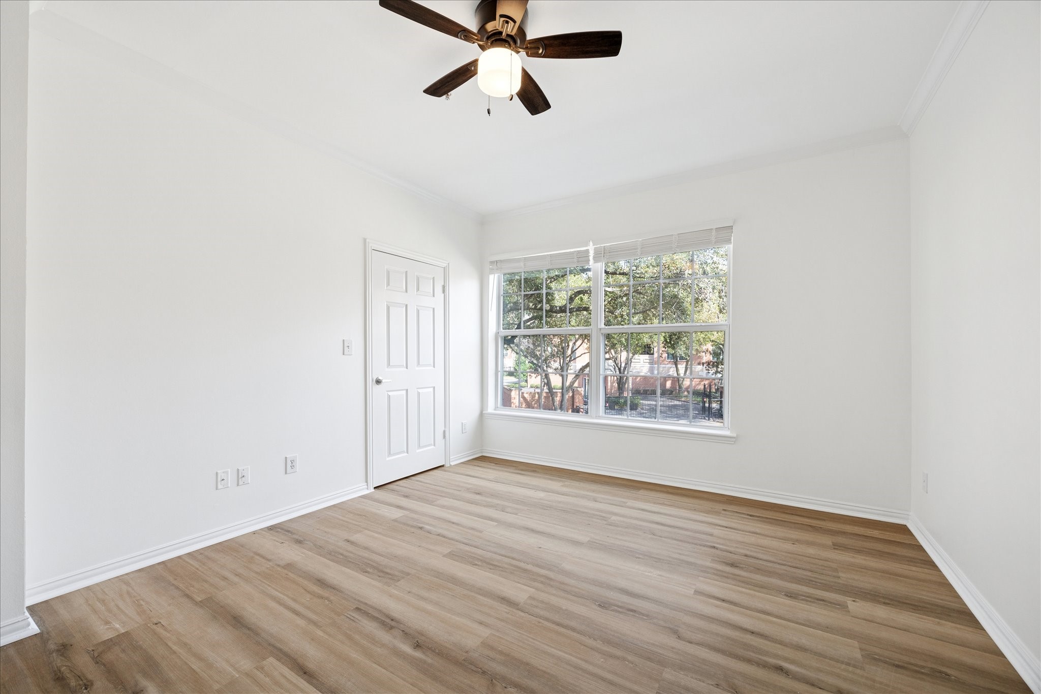 2111 Welch Street, Unit A103 Houston, TX 77019 - Photo 11 of 24 an empty room with wooden floor fan and windows
