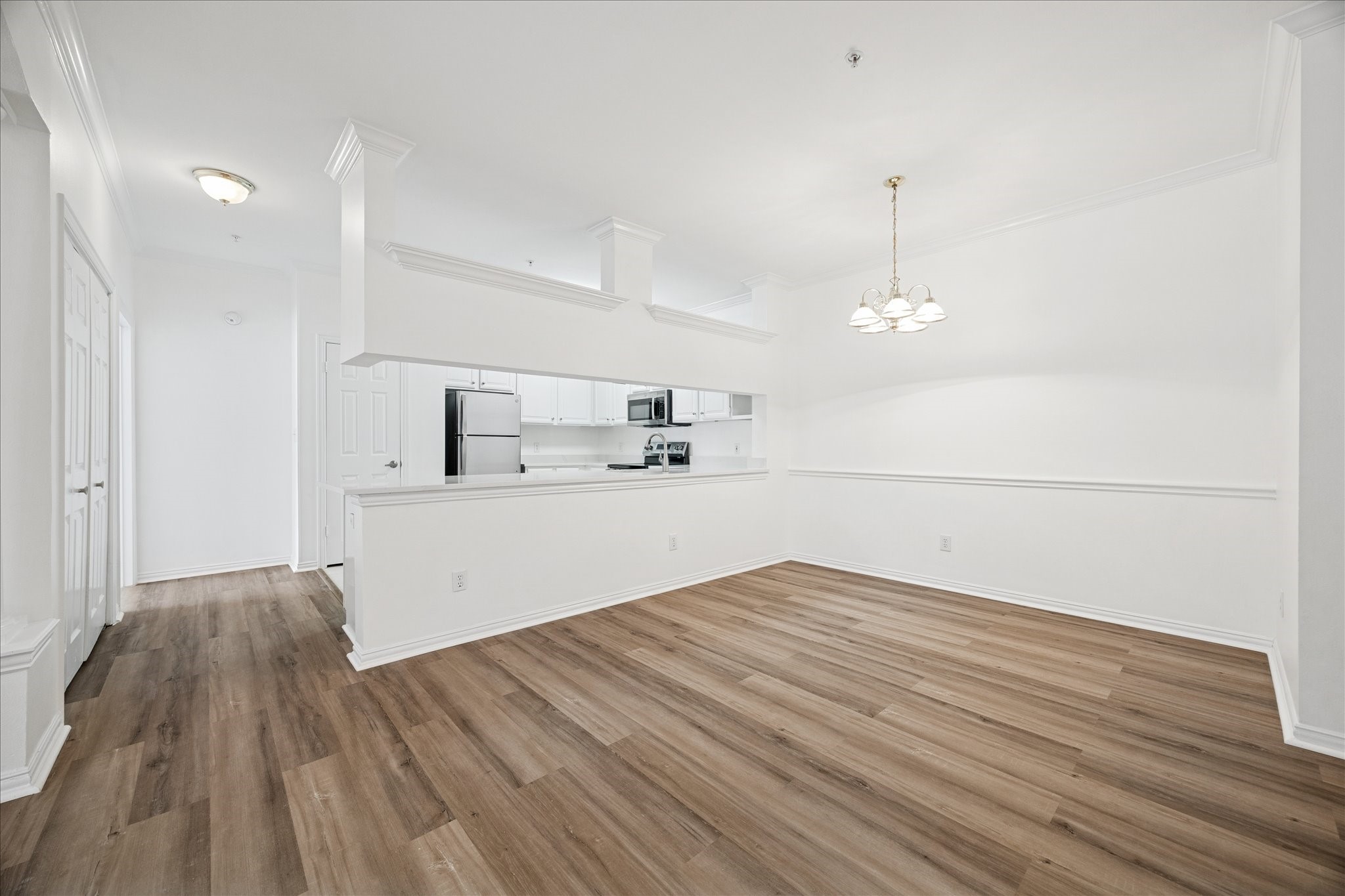 2111 Welch Street, Unit A103 Houston, TX 77019 - Photo 2 of 24 a view of kitchen and empty room with wooden floor