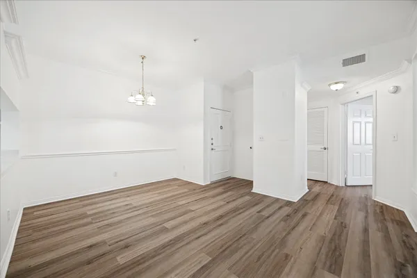 a view of empty room with wooden floor