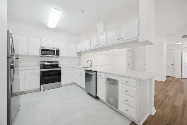 a kitchen with granite countertop white cabinets and stainless steel appliances