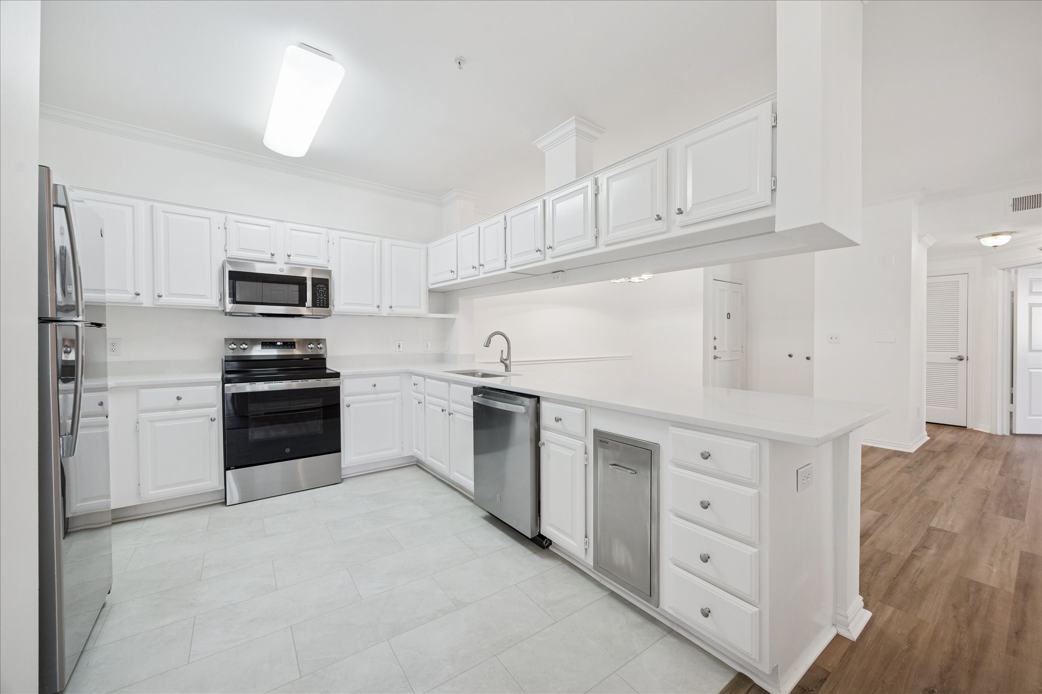 2111 Welch Street, Unit A103 Houston, TX 77019 - Photo 5 of 24 a kitchen with granite countertop white cabinets and stainless steel appliances