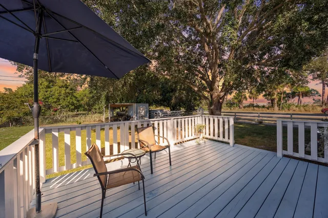 a view of a wooden house with a big yard and large trees