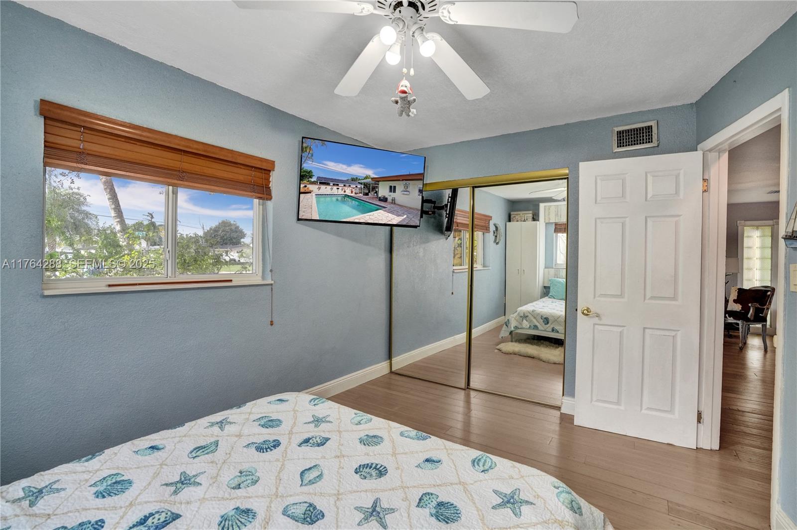 7825 Northwest 174th Street Hialeah, FL 33015 - Photo 14 of 30 a bedroom with a bed and a chandelier