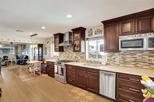 a kitchen with stainless steel appliances granite countertop a sink stove and cabinets