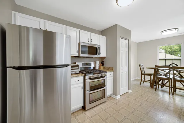 a kitchen with stainless steel appliances granite countertop a refrigerator stove and microwave