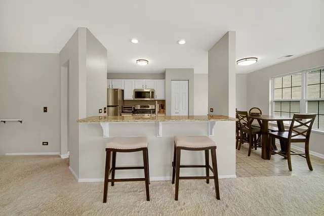 a kitchen with kitchen island cabinets and chairs in it