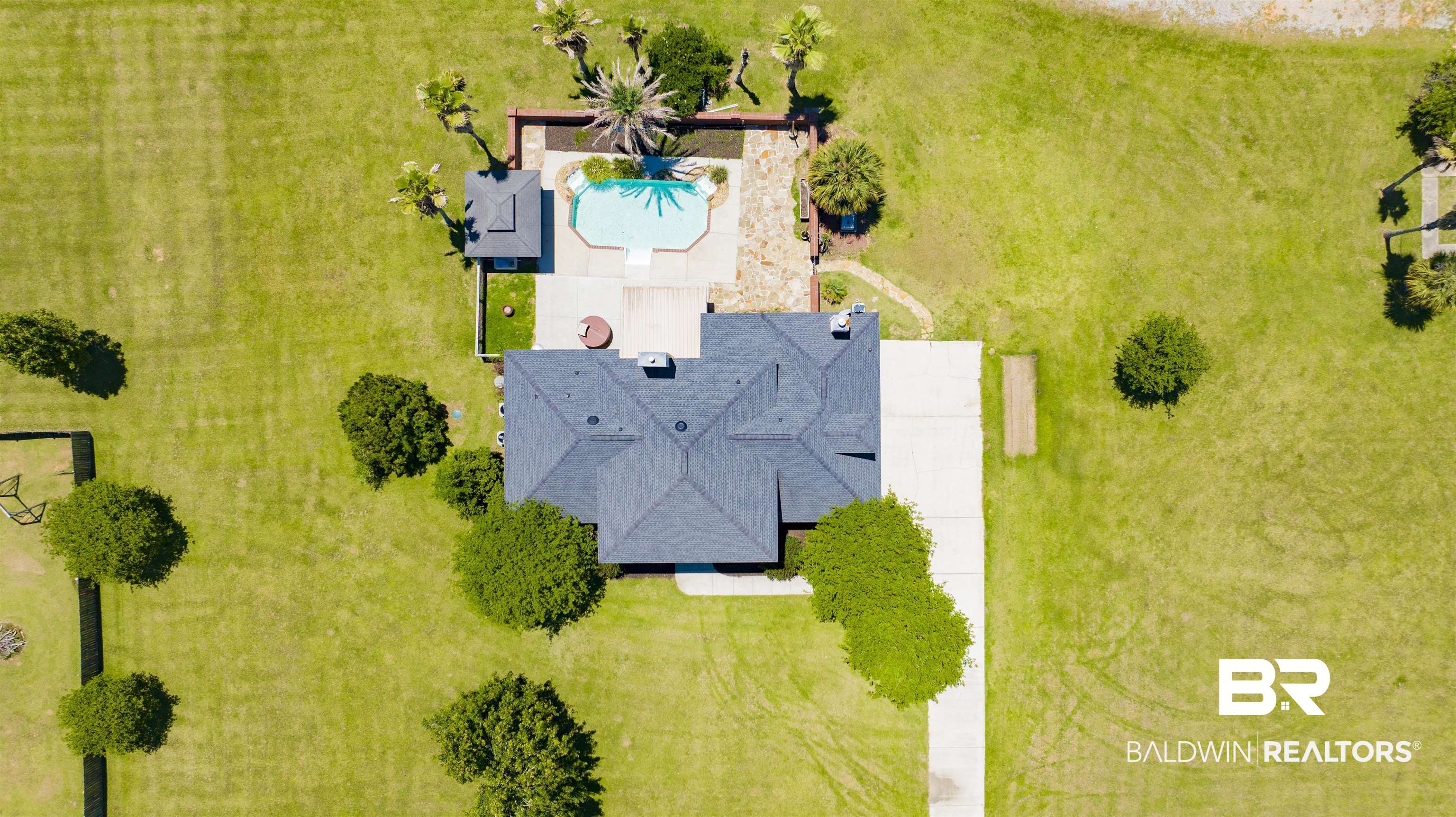 12944 Anna's Way Stapleton, AL 36578 - Photo 11 of 64 Expansive property featuring a dark shingle roof, a generously sized concrete driveway, a free-form swimming pool with surrounding patio, a hot tub, and a detached gazebo structure