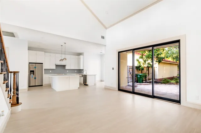 a large white kitchen with a large window
