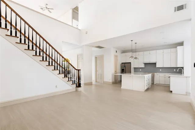 a open kitchen with white cabinets and white appliances