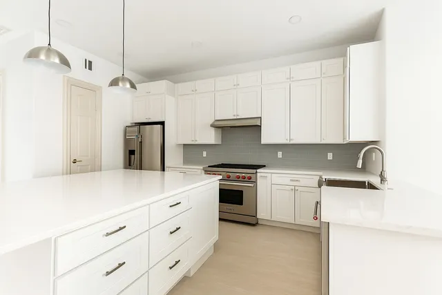 a kitchen with stainless steel appliances white cabinets and a sink