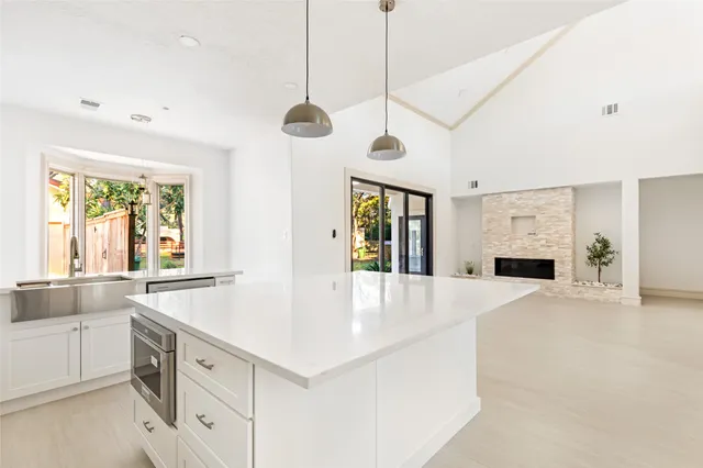 a large white kitchen with a large window