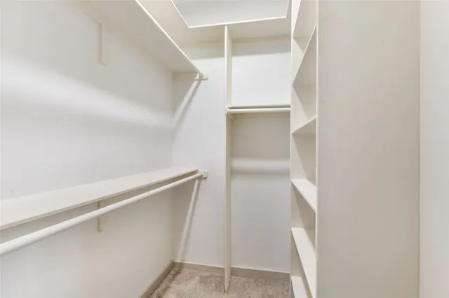 a view of walk in closet with empty racks