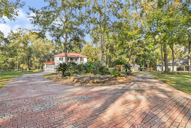 a sign board with yard and trees in the background