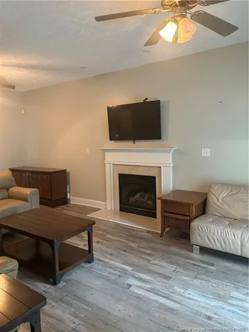 a living room with furniture a flat screen tv and a fireplace