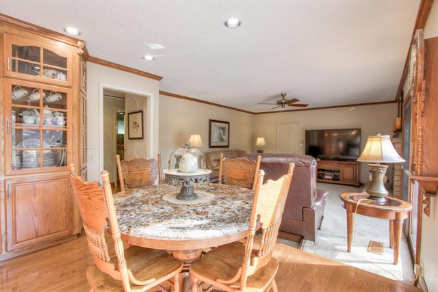 a living room with furniture a flat screen tv and kitchen view