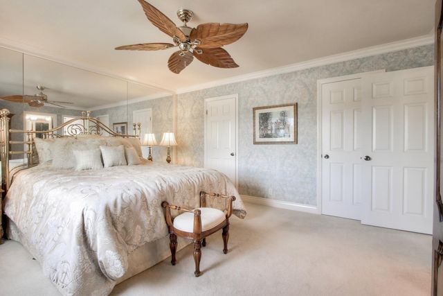 a spacious bedroom with a bed and a chandelier