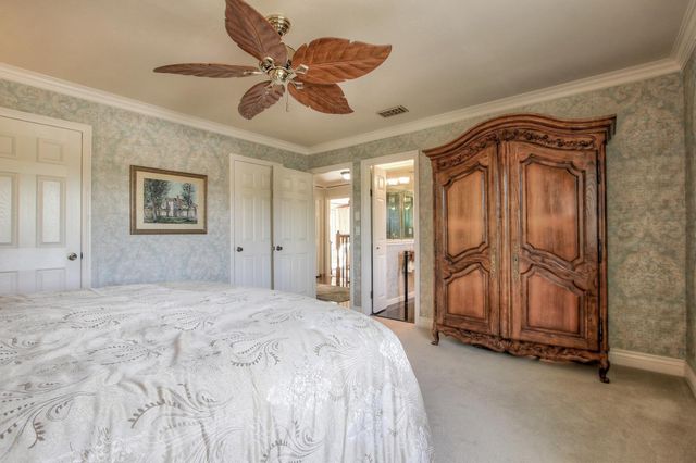a spacious bedroom with a bed and a chandelier