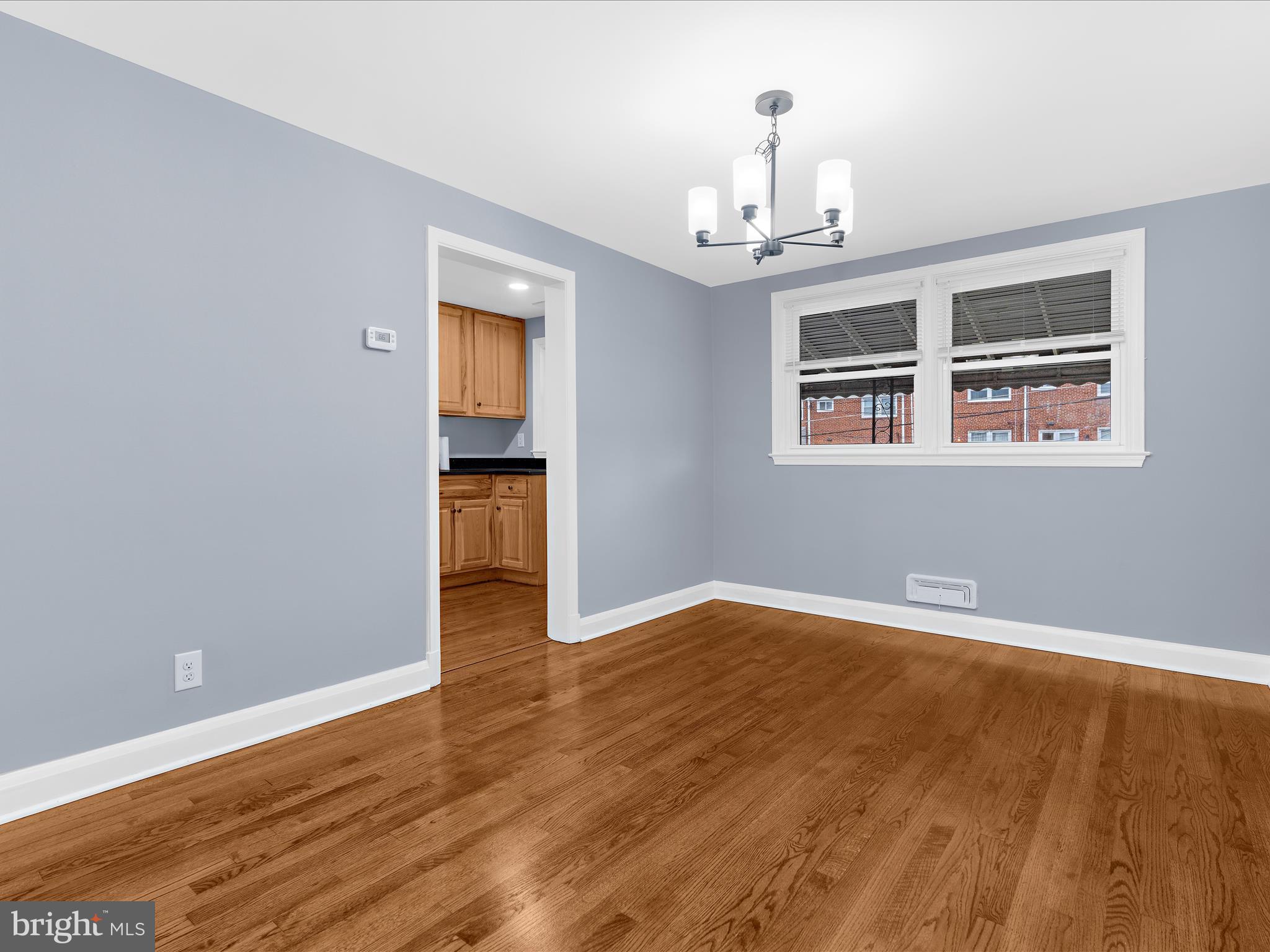 1427 Barrett Road Baltimore, MD 21207 - Photo 11 of 40 a view of an empty room with wooden floor and a window