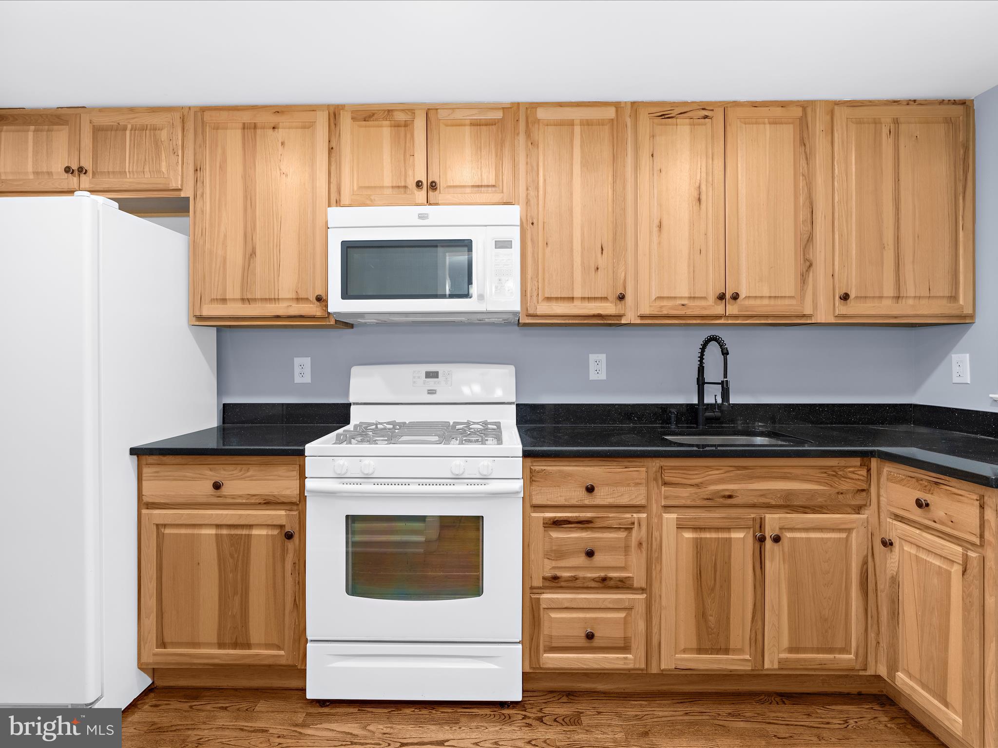 1427 Barrett Road Baltimore, MD 21207 - Photo 15 of 40 a kitchen with granite countertop white cabinets and stainless steel appliances