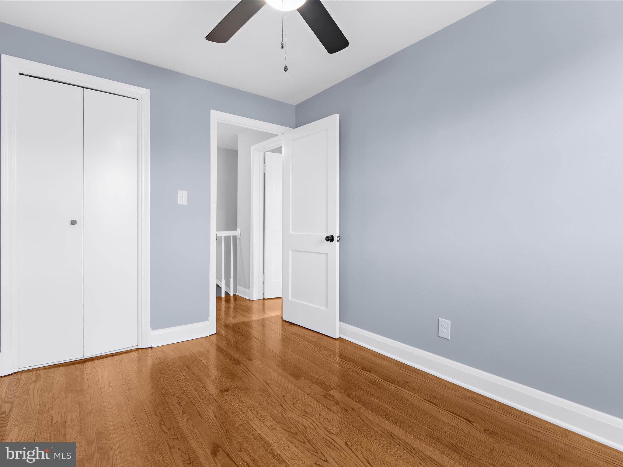 1427 Barrett Road Baltimore, MD 21207 - Photo 23 of 40 an empty room with wooden floor and ceiling fan