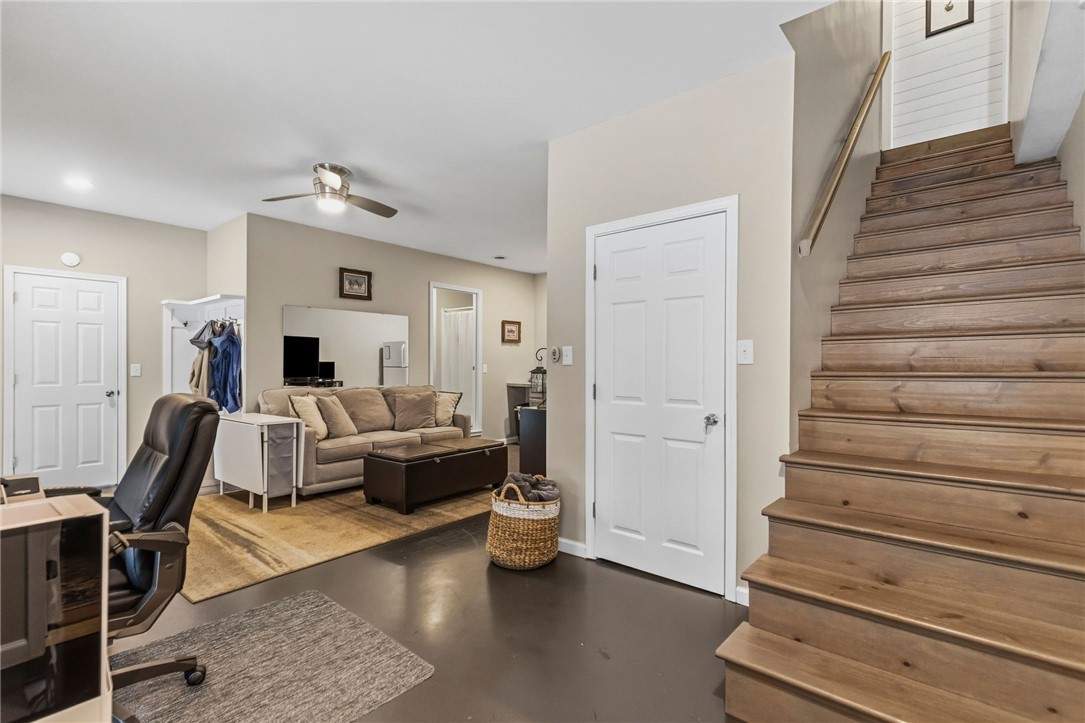 641 Lands End Road Seneca, SC 29678 - Photo 23 of 39 A well-lit living area features rich dark flooring and a warm wood staircase, creating a versatile and inviting space.