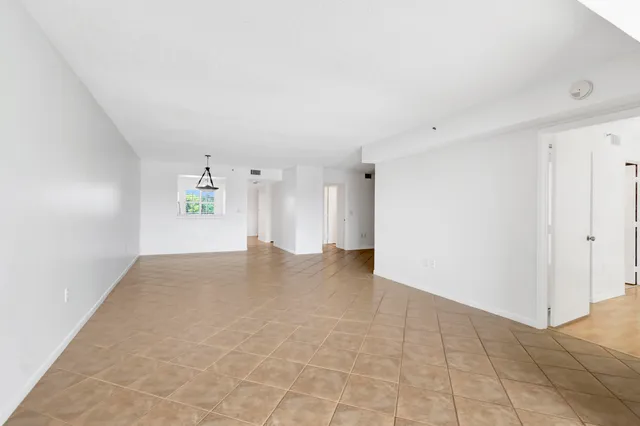 an empty room with a ceiling fan and carpet