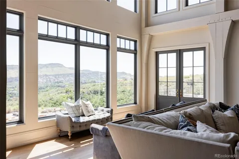 a living room with furniture and floor to ceiling windows