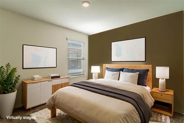 a bedroom with a large bed and a potted plant