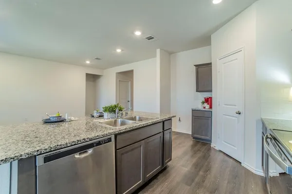 a kitchen with granite countertop a sink and cabinets