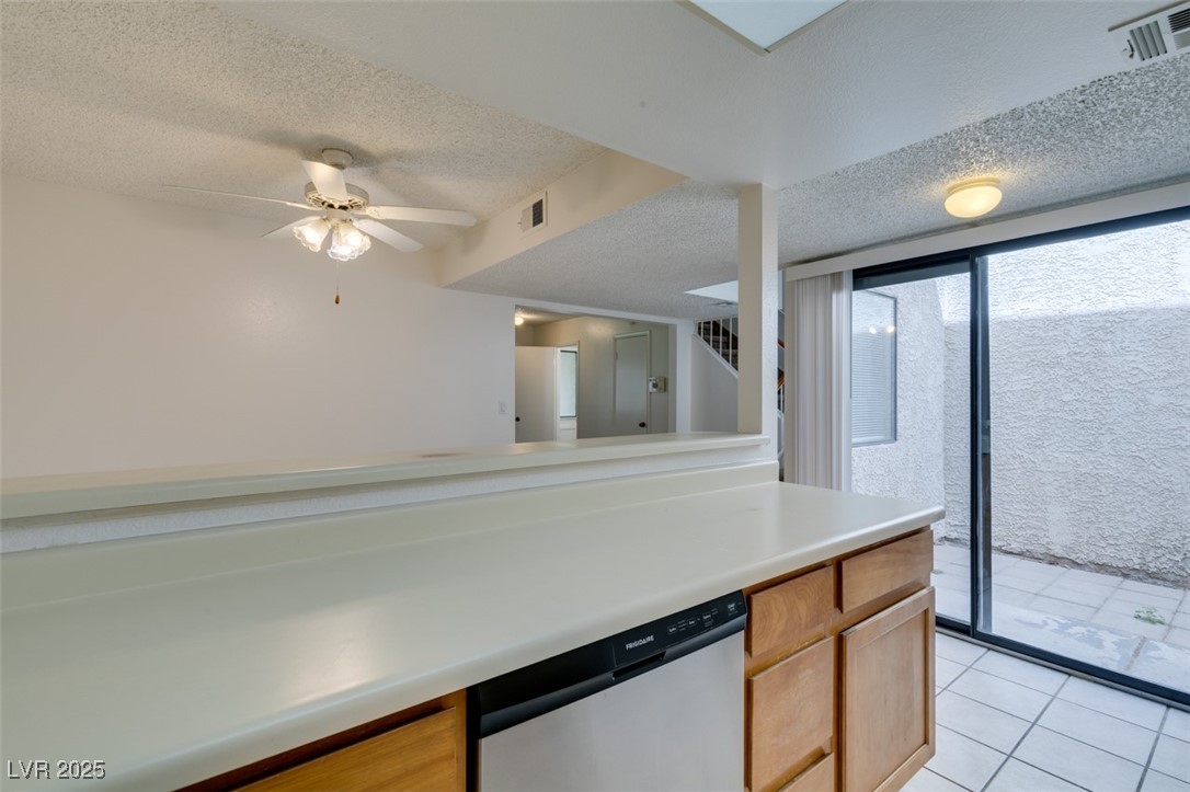 2681 Ruthe Duarte Avenue Las Vegas, NV 89121 - Photo 27 of 43 Kitchen featuring light tile patterned floors, light countertops, a textured ceiling, visible vents, and dishwasher