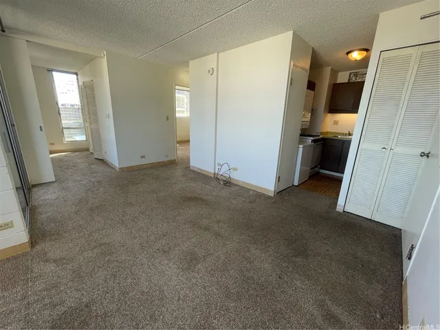 a view of a kitchen with furniture and a refrigerator