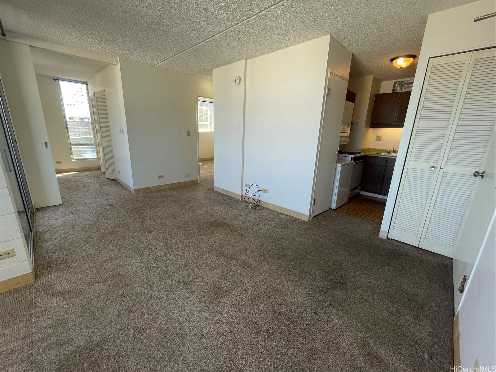 1624 Dole Street, Unit 804 Honolulu, HI 96822 - Photo 3 of 8 a view of a kitchen with furniture and a refrigerator