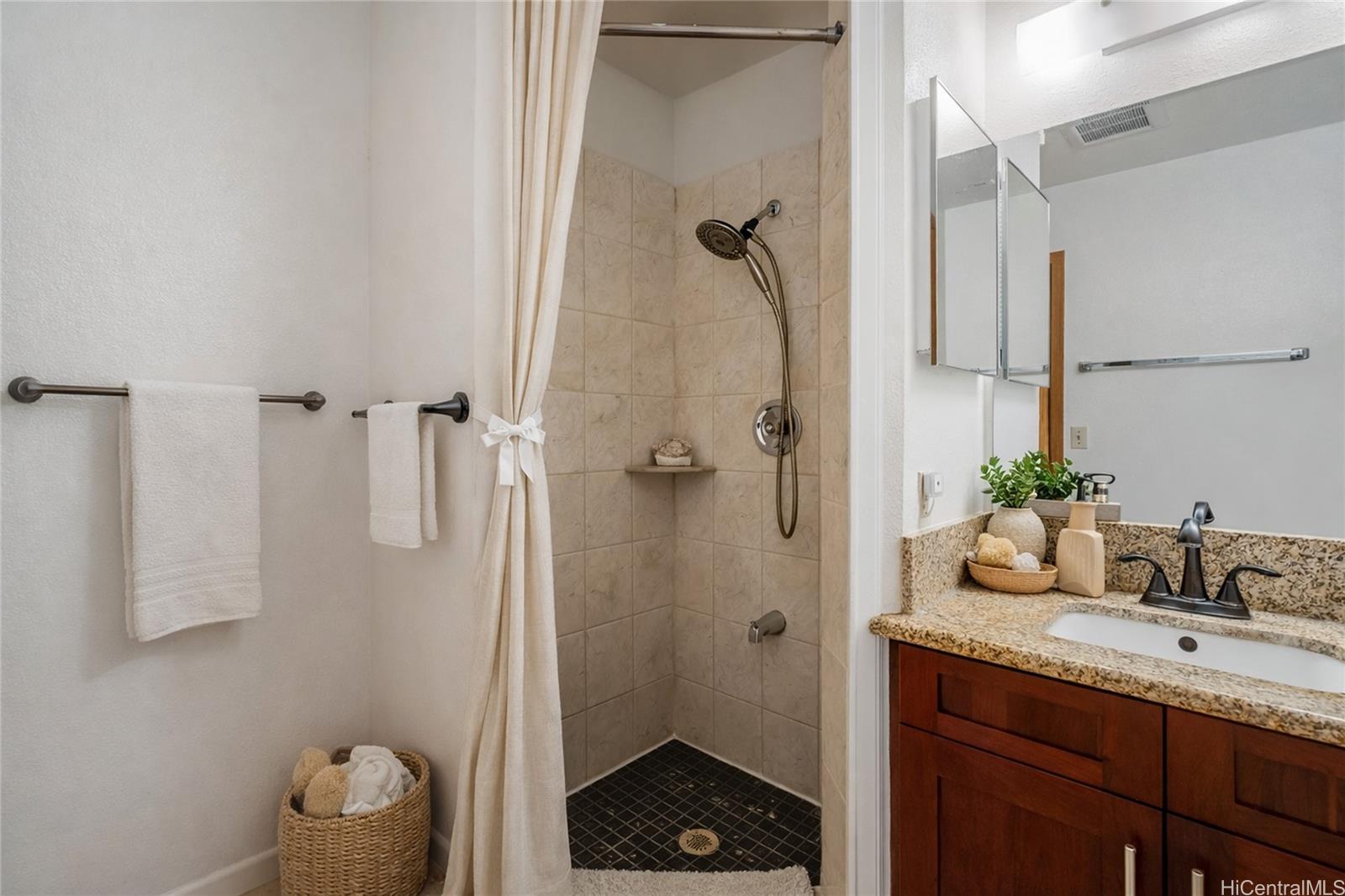 98-941 Moanalua Road, Unit 403 Aiea, HI 96701 - Photo 11 of 19 a bathroom with a granite countertop sink a mirror a vanity and shower