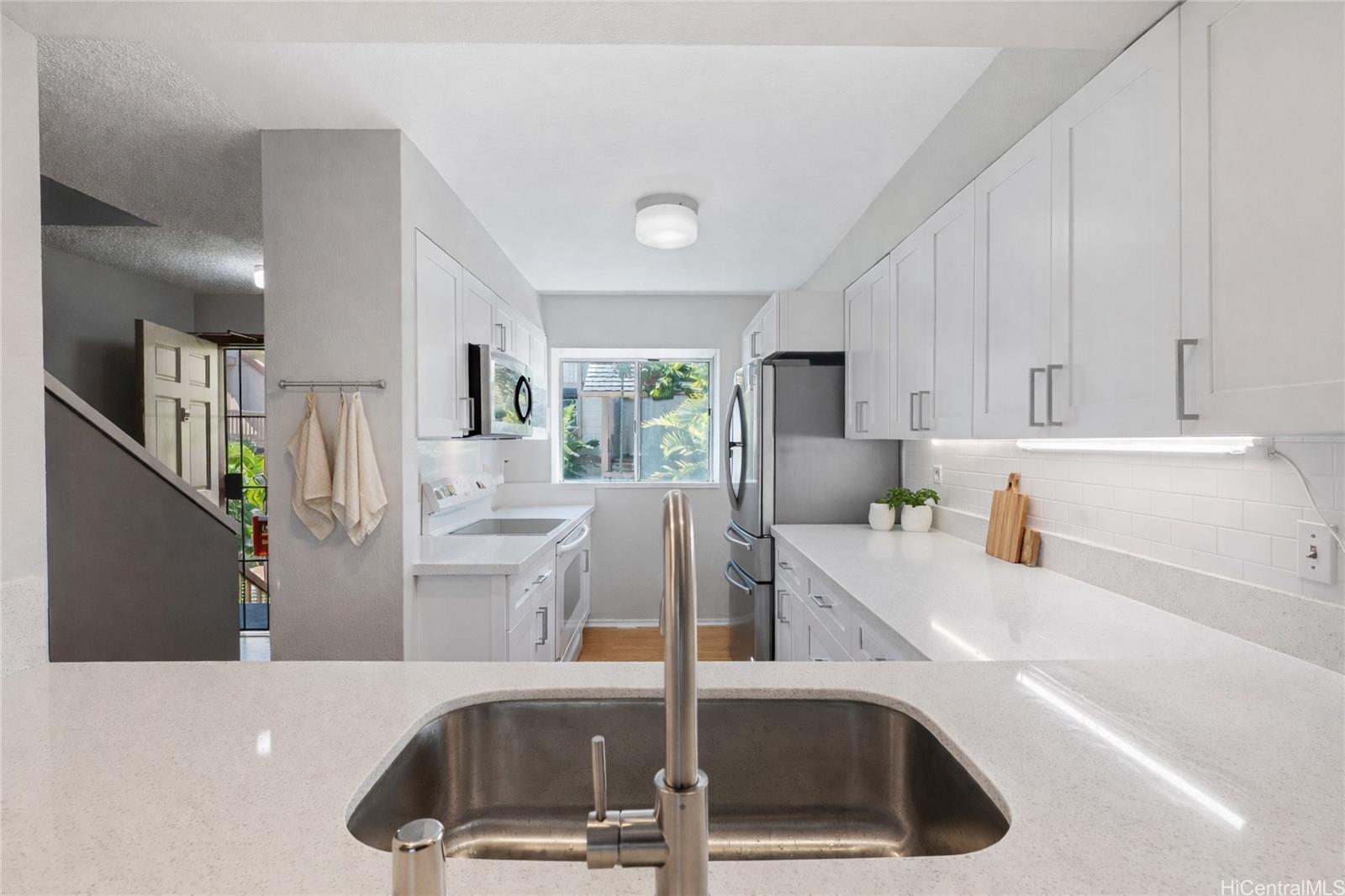 98-941 Moanalua Road, Unit 403 Aiea, HI 96701 - Photo 5 of 19 a kitchen with a sink a refrigerator and cabinets