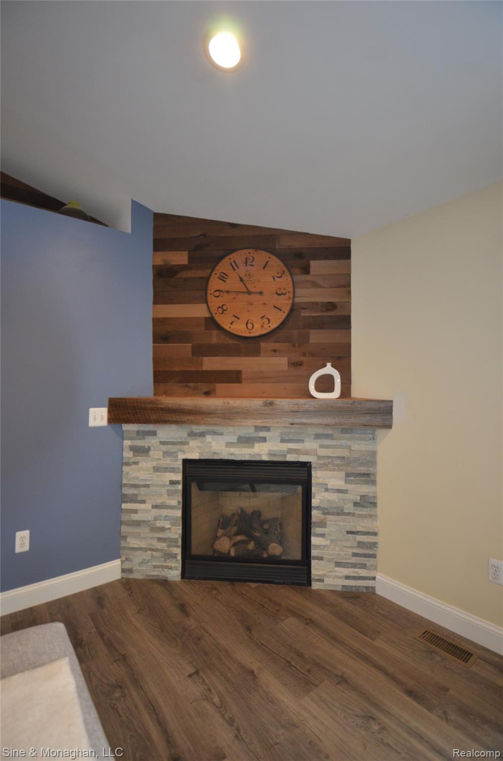76152 Burman Road Richmond, MI 48062 - Photo 14 of 75 Detailed view of a stone fireplace, an accent wall, wood finished floors, and wooden walls