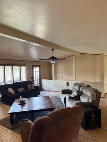 a living room with furniture kitchen view and a window