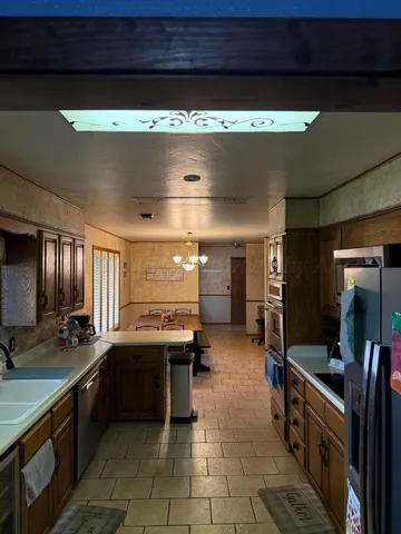 a large kitchen with a counter space a sink and cabinets