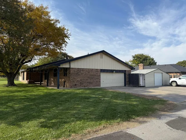 a front view of a house with a yard and trees