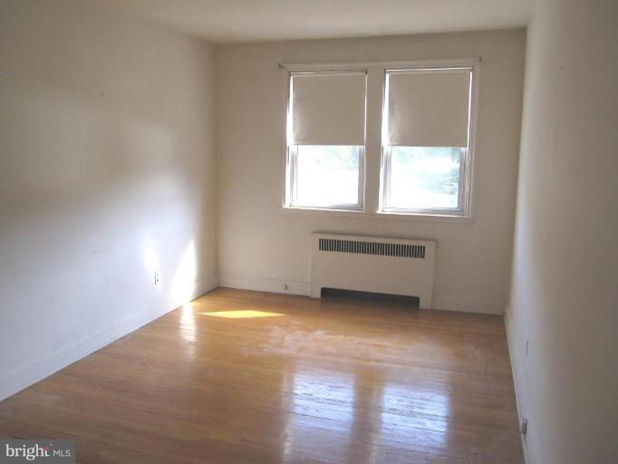 6431 Blenheim Road Baltimore, MD 21212 - Photo 10 of 12 a view of an empty room with wooden floor and a window