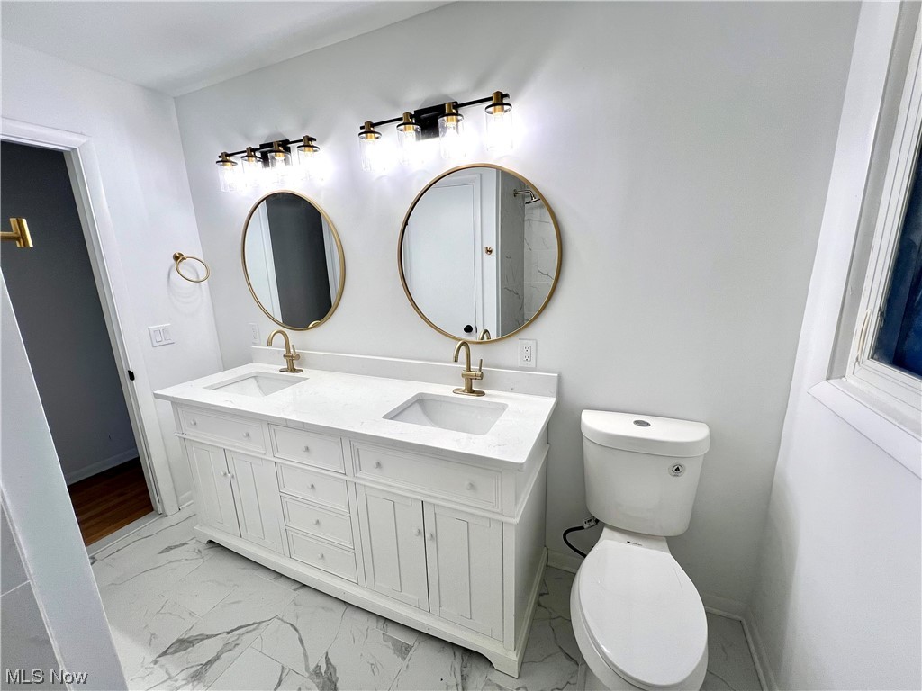 7687 Ragall Parkway Cleveland, OH 44130 - Photo 22 of 37 Bathroom featuring dual bowl vanity, tile flooring, and toilet