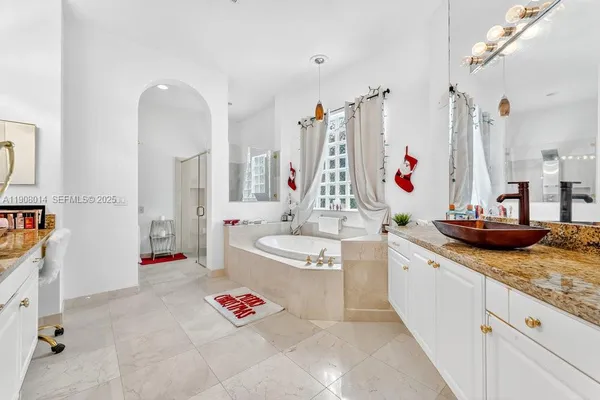 a bathroom with a granite countertop tub sink and a mirror
