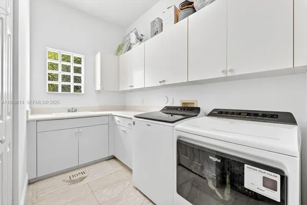 a utility room with cabinets washer and dryer