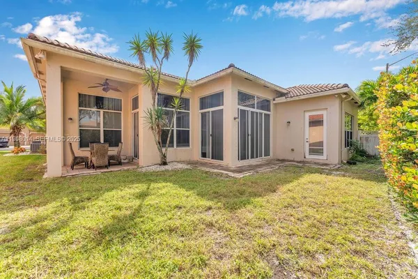 a view of a house with backyard and sitting area