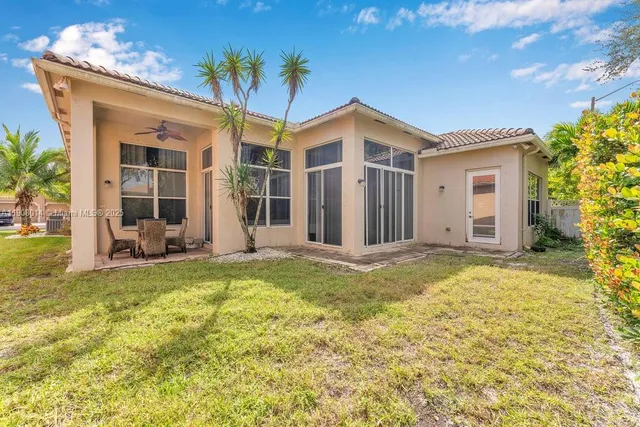 a view of a house with backyard and sitting area