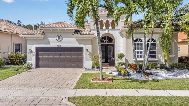 a front view of a house with yard and green space