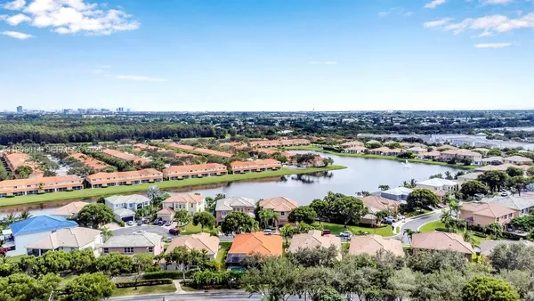 an aerial view of city and lake with trees all around