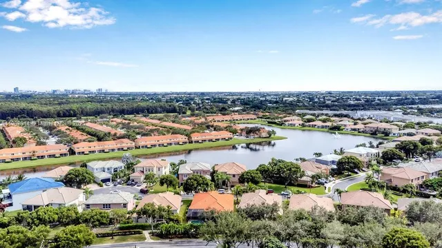 an aerial view of city and lake with trees all around